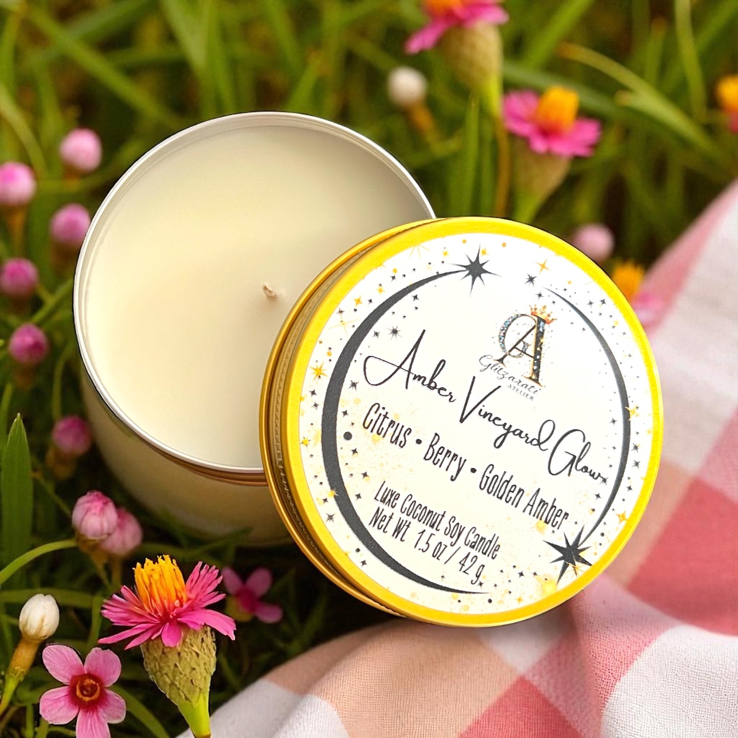 Open candle tin with a label on a grassy background with flowers