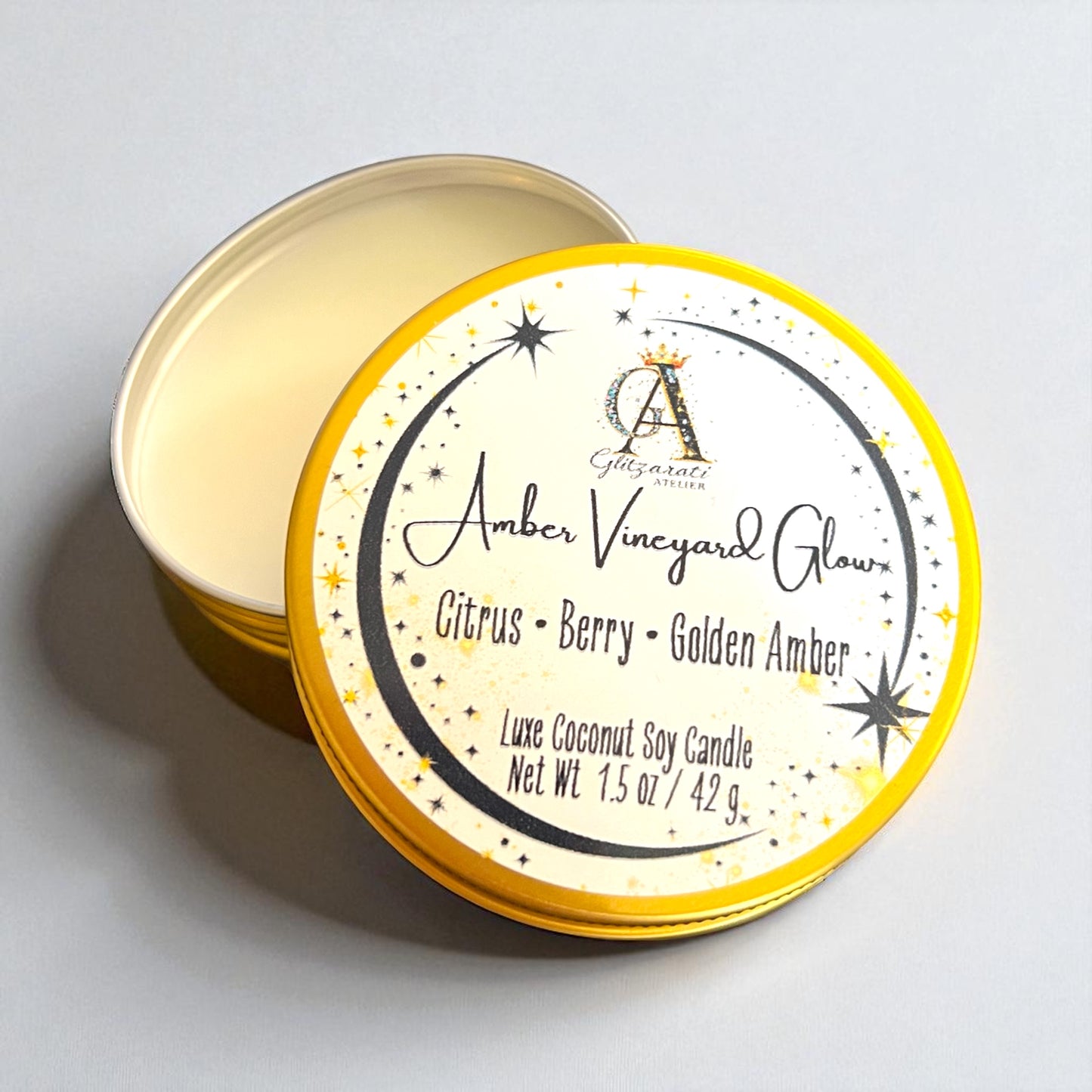 Candle tin labeled 'Amber Vineyard Glow' with a starry night design on a light gray background