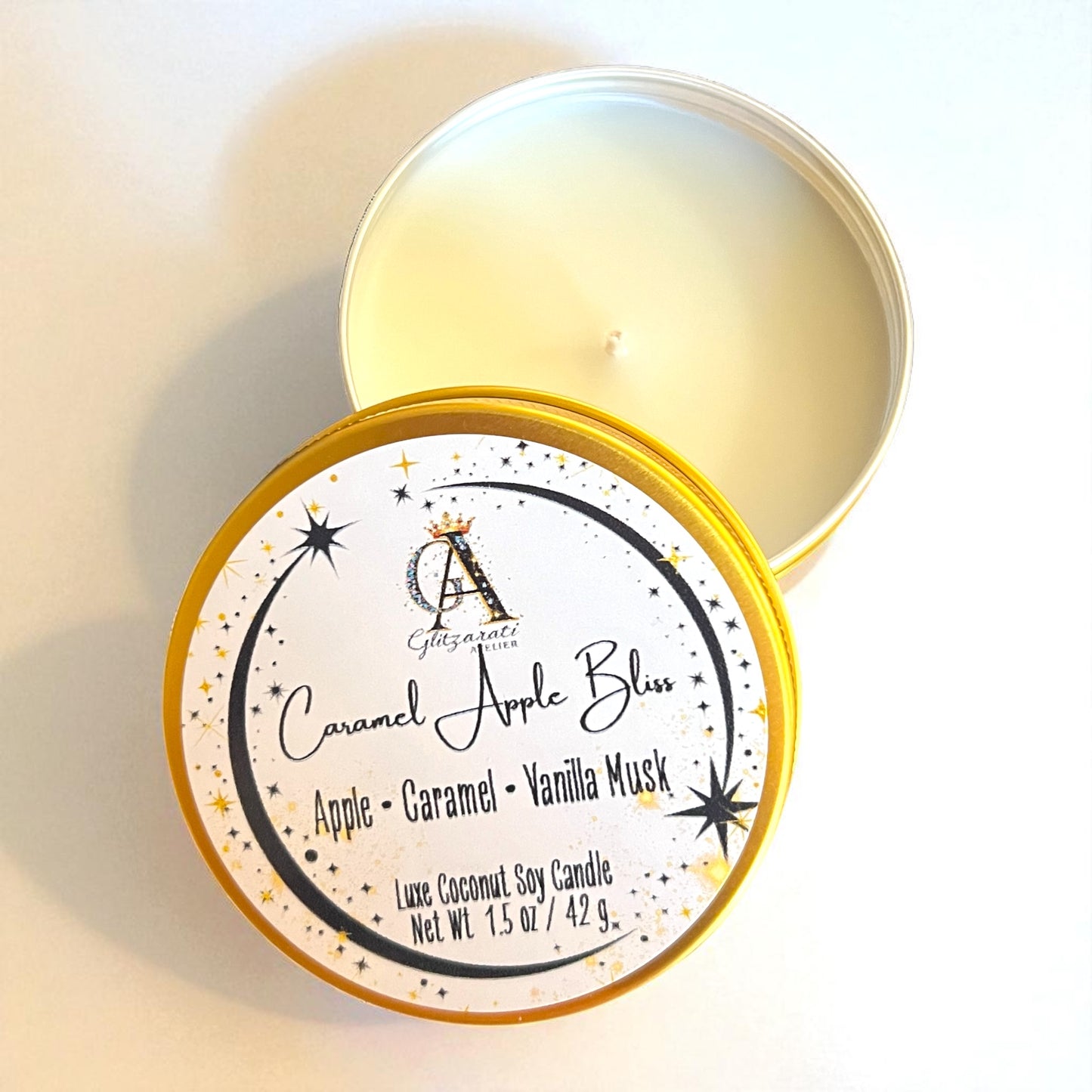 Candle in a tin with 'Caramel Apple Bliss' label on a light background