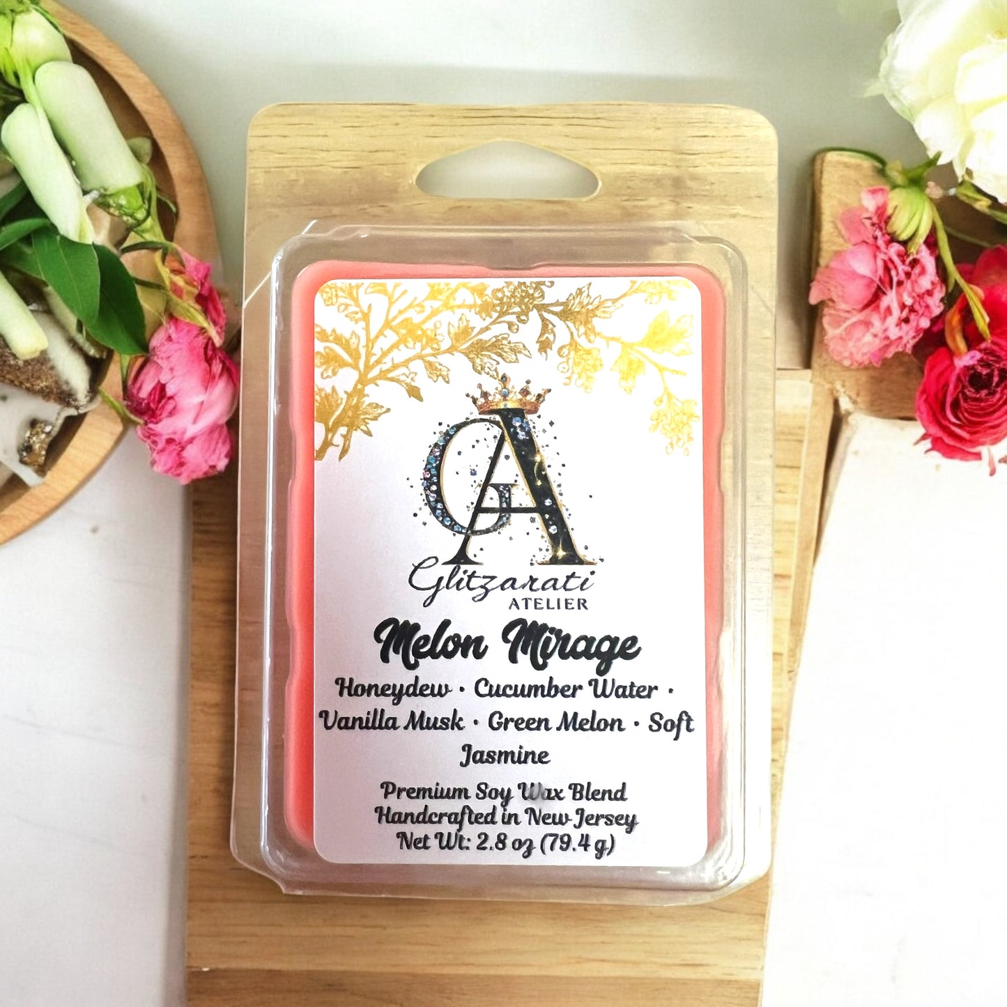 Scented wax melt package with floral design and branding on a wooden surface.