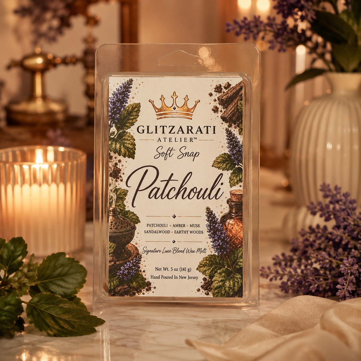 Glitzarati Atelier Patchouli wax melt packaging with decorative elements on a soft focus background.