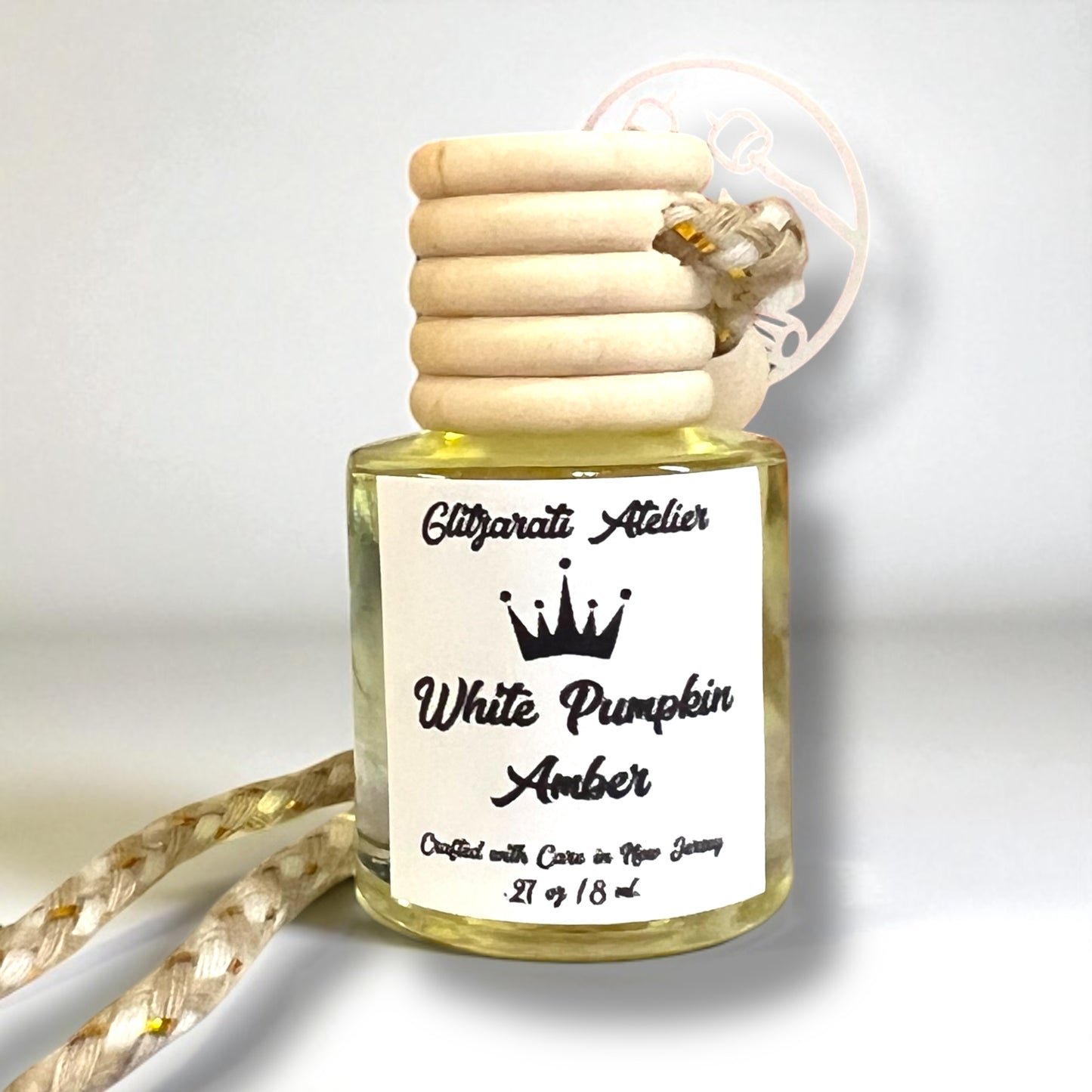 Small bottle of 'White Pumpkin Amber' fragrance with wooden cap on a white background
