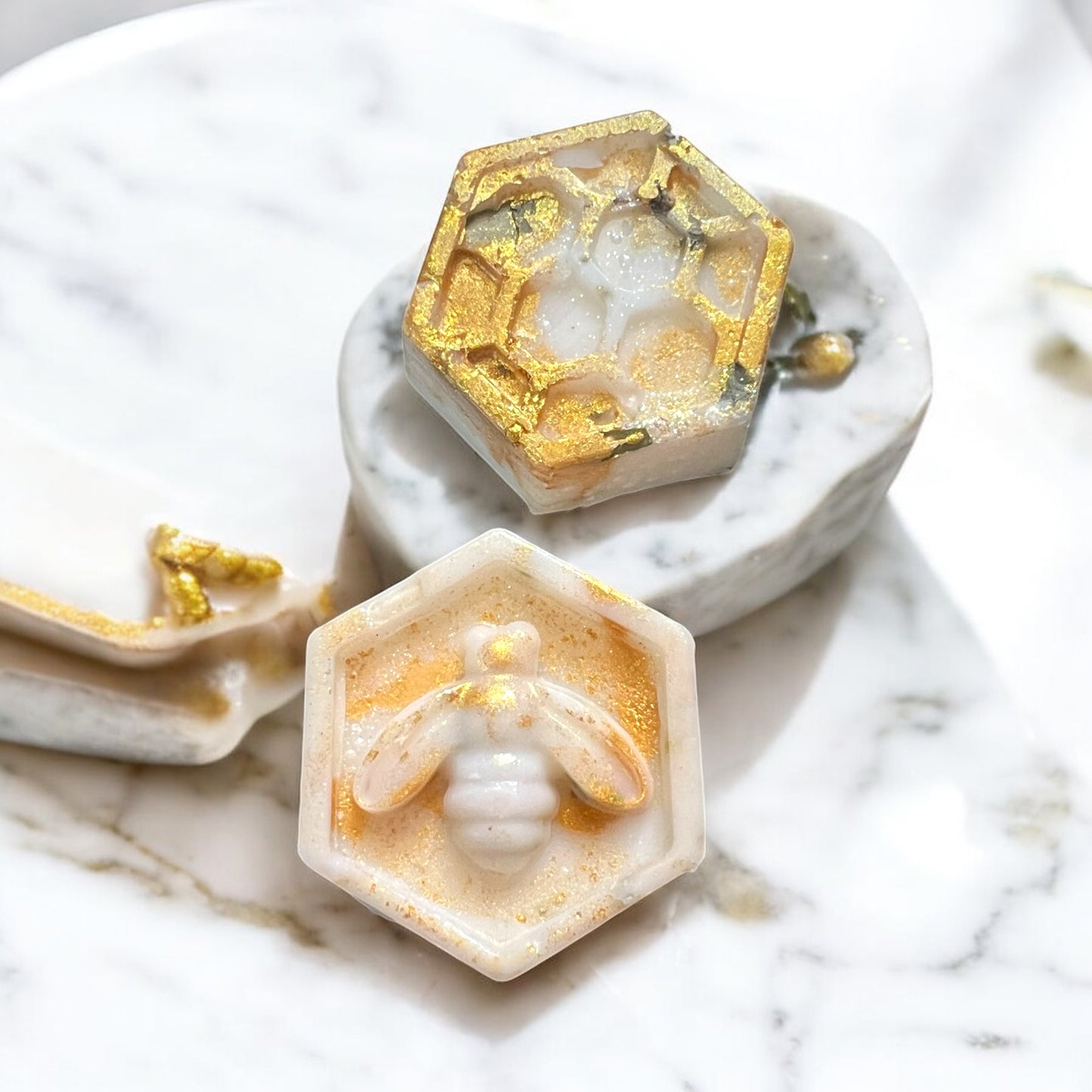 Hexagonal soap bars with gold accents on a marble surface
