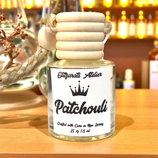 Patchouli essential oil bottle with wooden cap on a wooden surface, blurred background