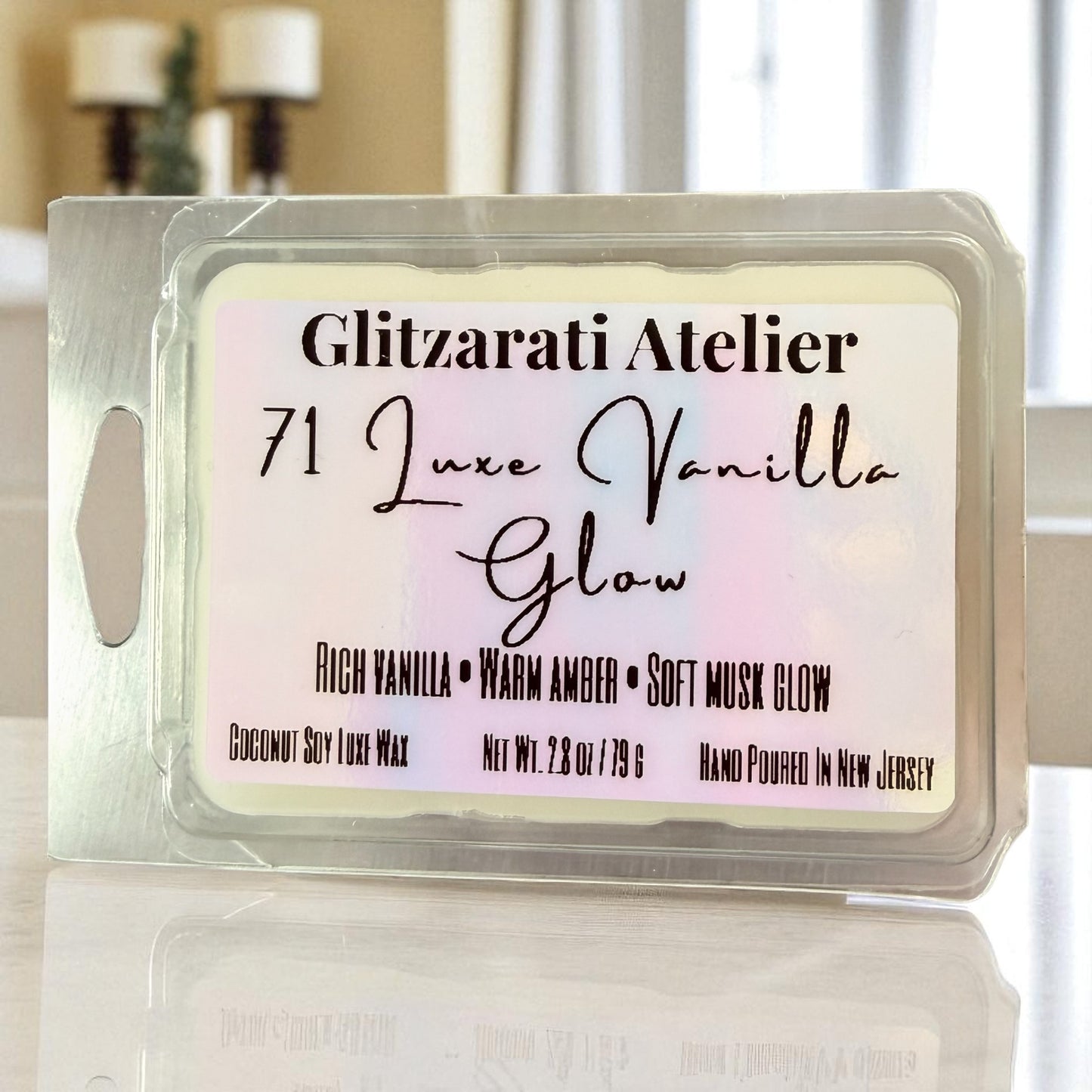 Wax melt package labeled 'Glitzarati Atelier 71 Luxe Vanilla Glow' on a reflective surface.
