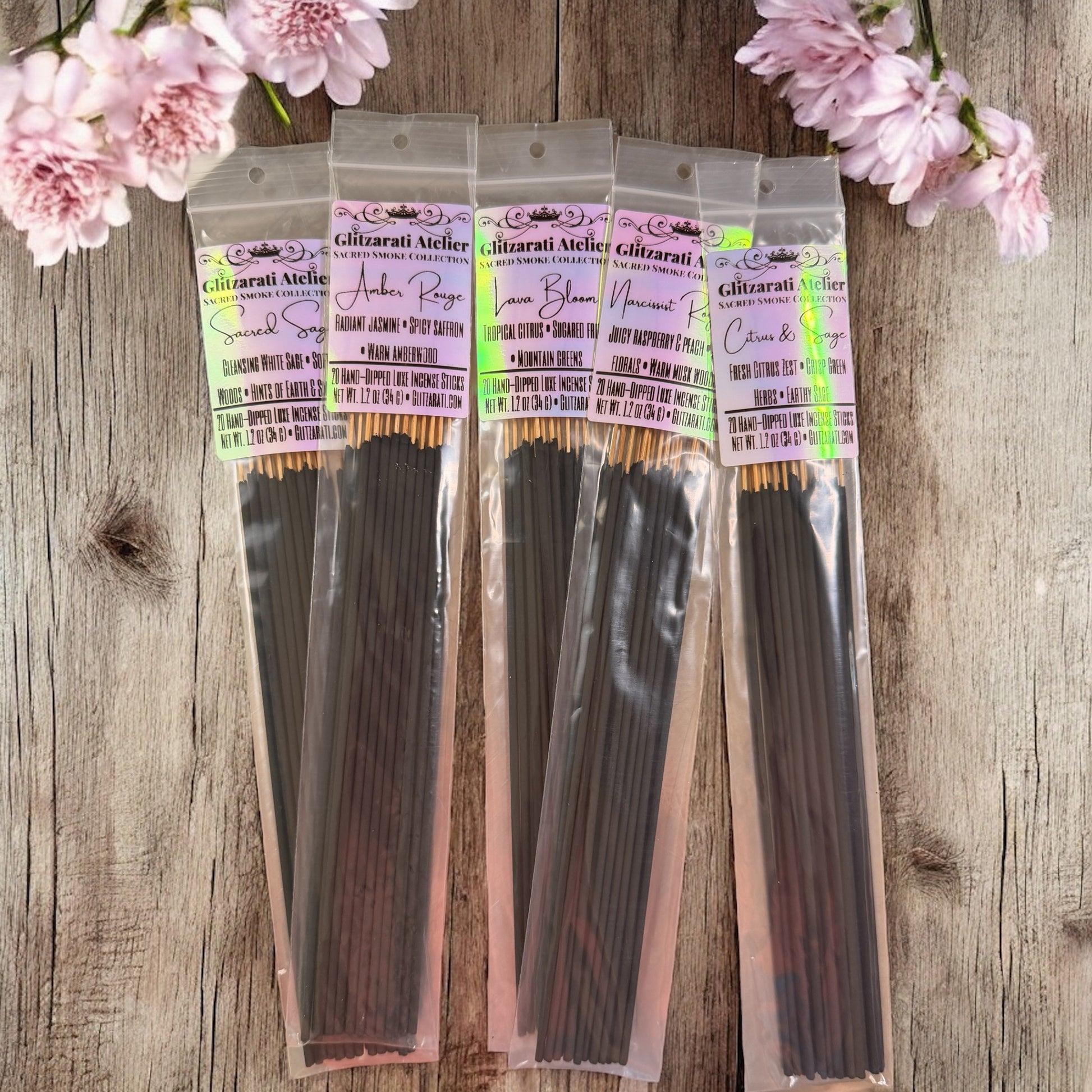 Three packages of hair extensions on a wooden surface with pink flowers.