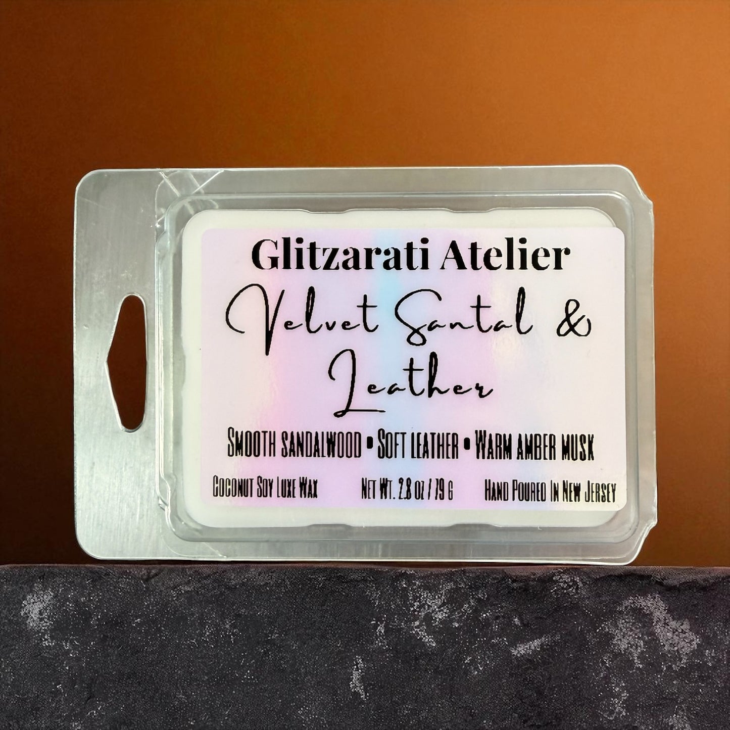 Wax melt packaging with 'Glitzerati Atelier' label on a brown background