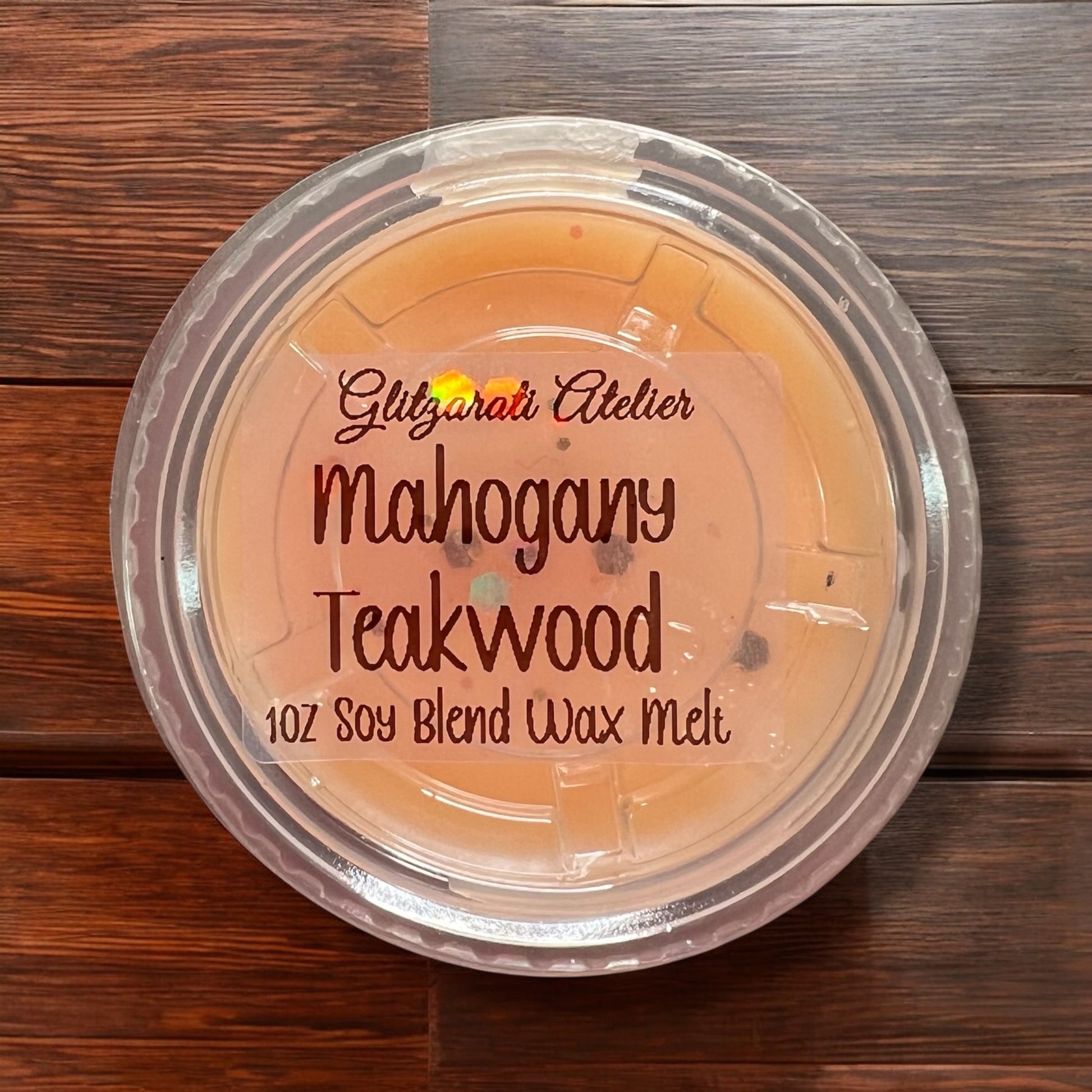 Container of Glitzgirati Atelier Mahogany Teakwood wax melt on a wooden surface