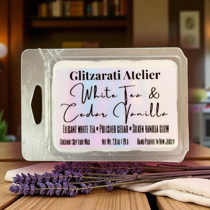 Wax melt packaging with 'Glitzerati Atelier' branding on a wooden surface with lavender.