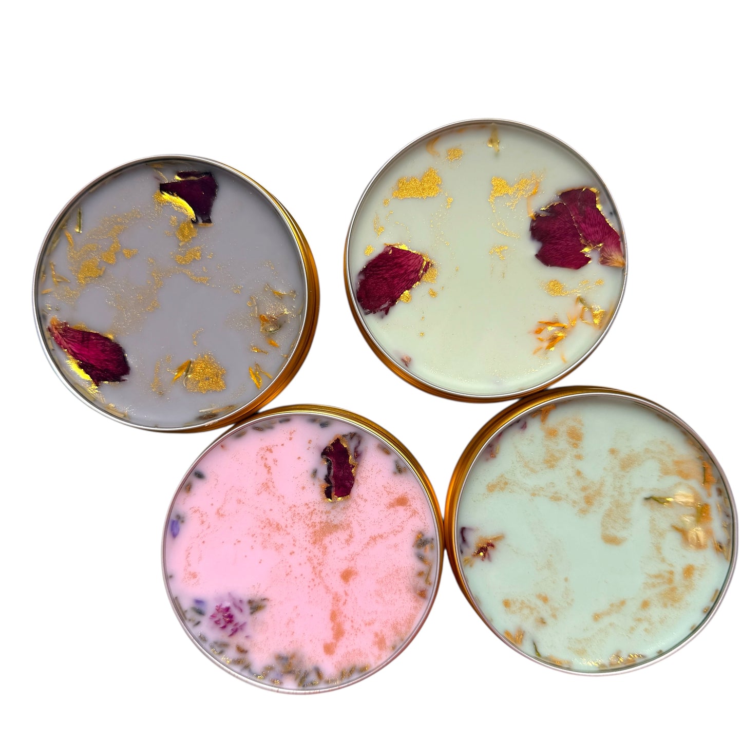 Four round ceramic coasters with gold leaf and red rose petals on a white background
