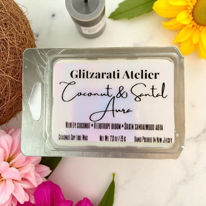 Wax melt packaging with 'Glitzerati Atelier' branding and floral decorations on a marble surface.