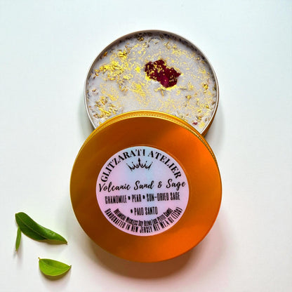 Open container of Volcanic Sand & Sage soap with a visible brand label on a white background