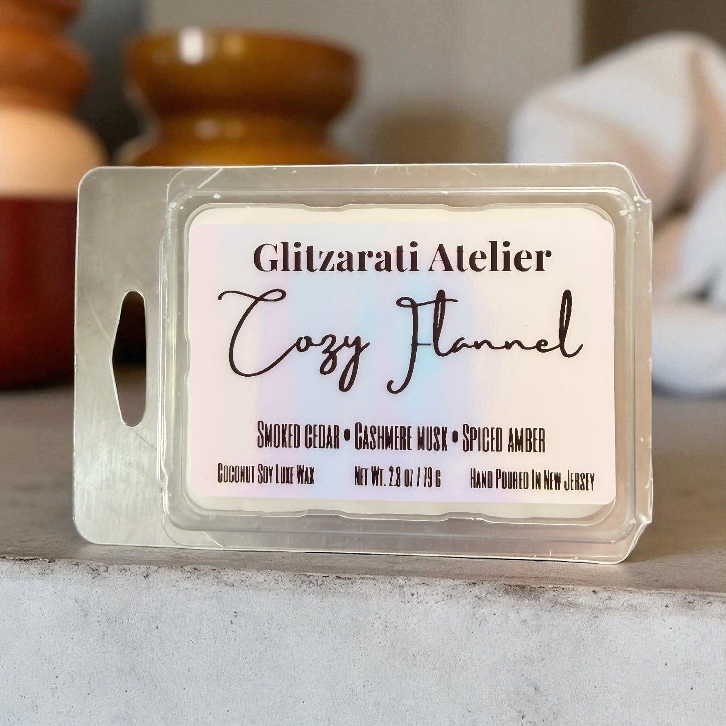 Wax melt package labeled 'Cozy Flannel' by Glitzarati Atelier on a neutral background.