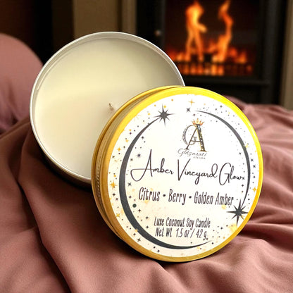Candle in a tin with 'Amber Vineyard Glow' label against a warm background