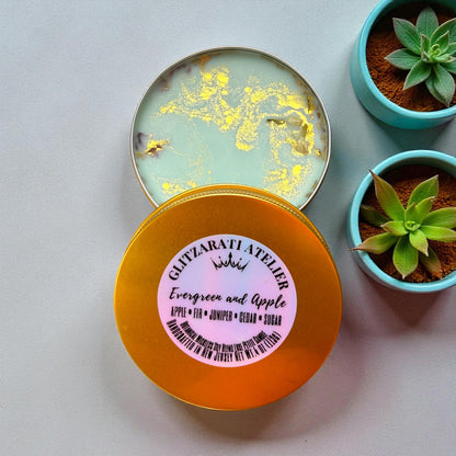 Round container with a pink label on a light gray background with potted plants.