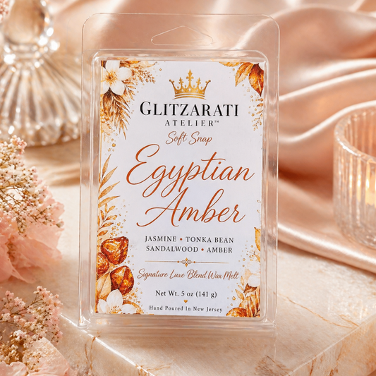 Glitzerati Atelier Egyptian Amber soft soap packaging on a decorative background with flowers and candles.