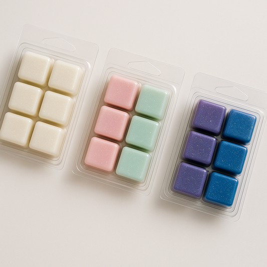 Three packages of colorful square wax melts on a light background