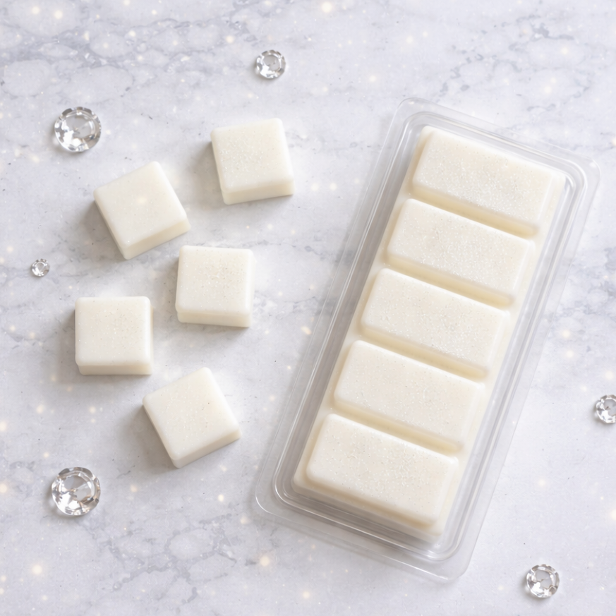 White wax melts in a clear mold on a gray marble surface with decorative crystals.