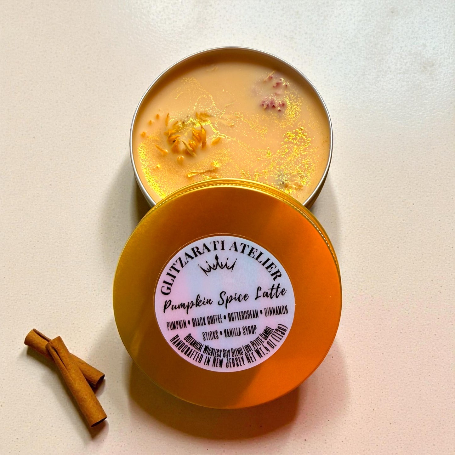 Pumpkin spice latte candle in a tin with a visible brand label on a light background