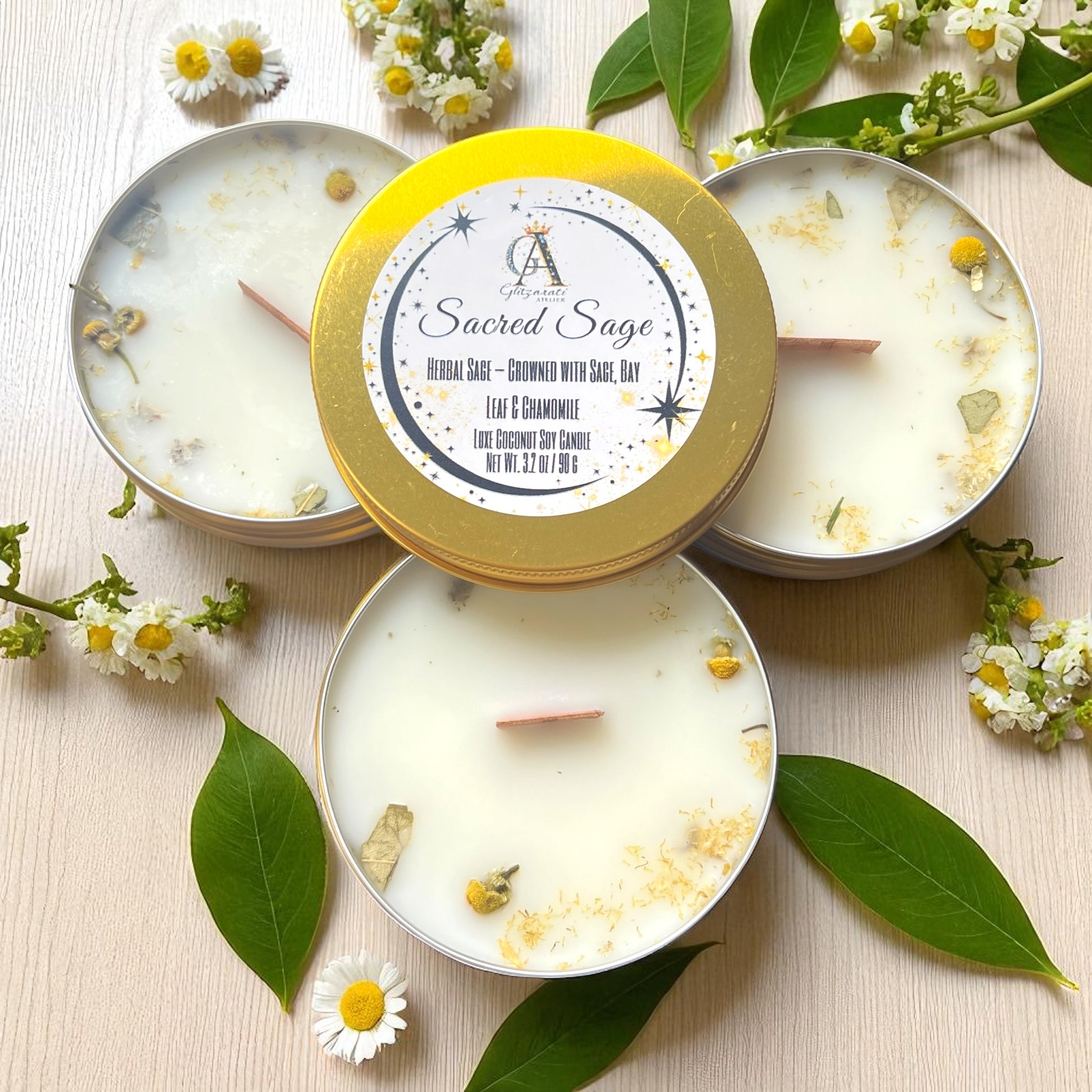 Candle with 'Sacred Sage' label surrounded by leaves and flowers on a light background
