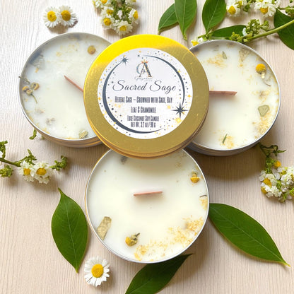 Candle with 'Sacred Sage' label surrounded by leaves and flowers on a light background