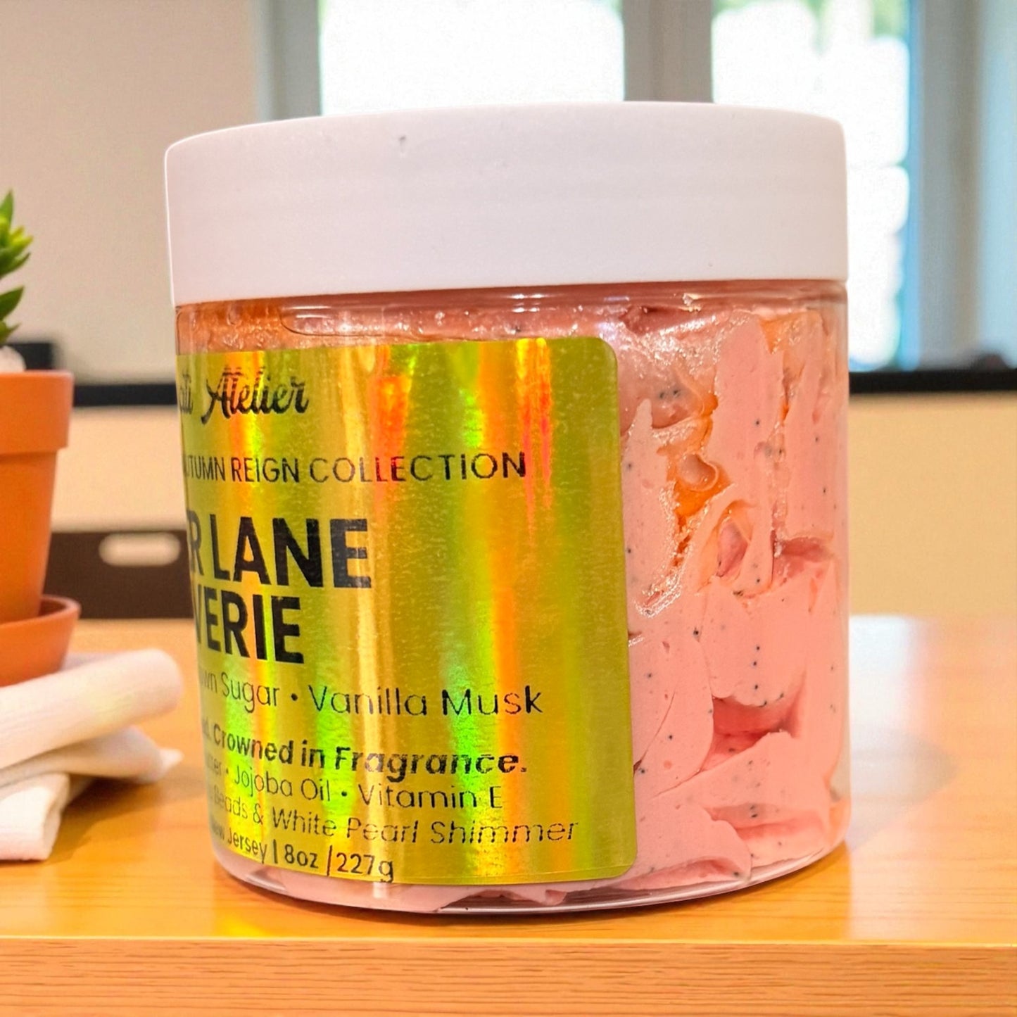 Jar of pink cream with colorful label on a wooden surface