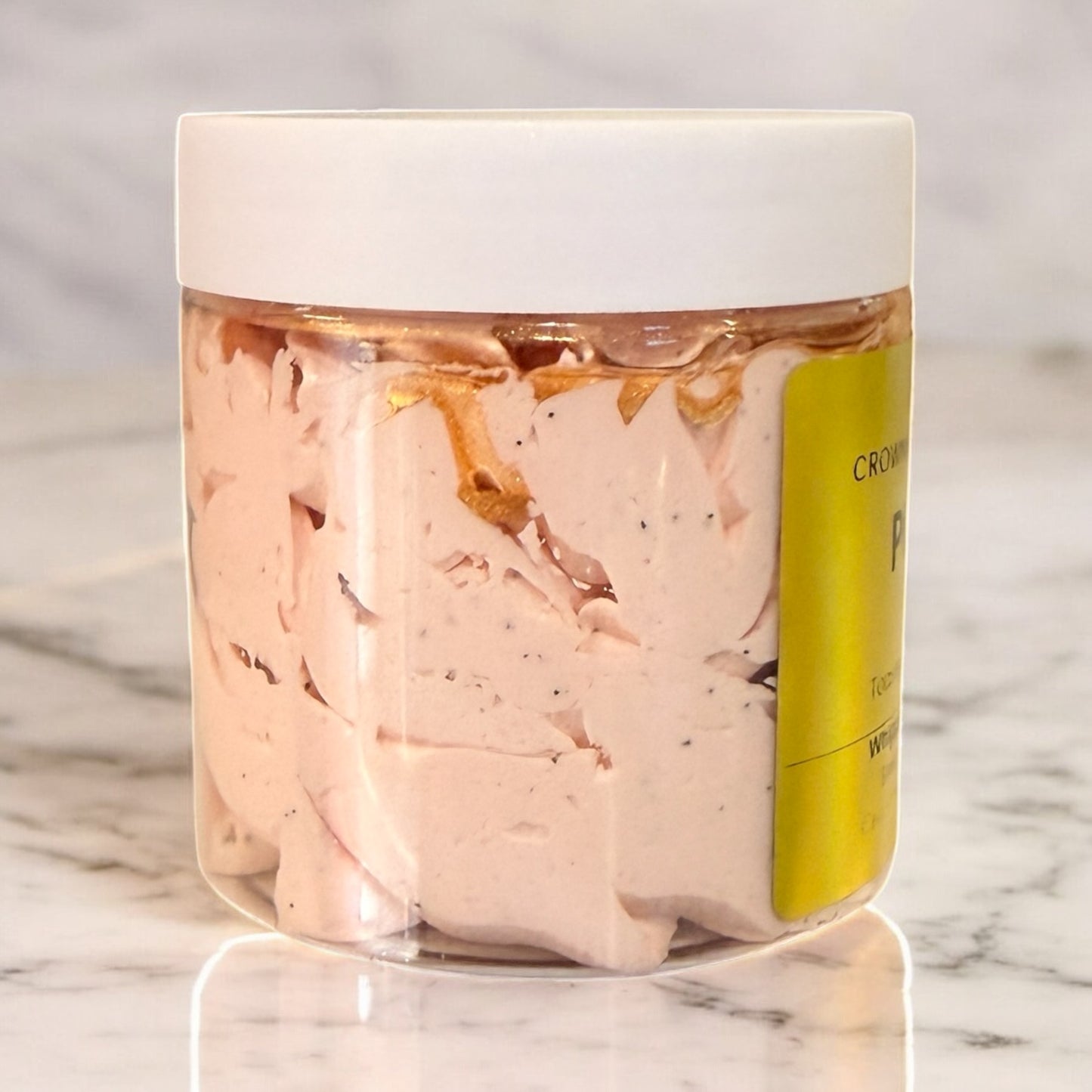Jar of pink cream with a white lid on a marble surface