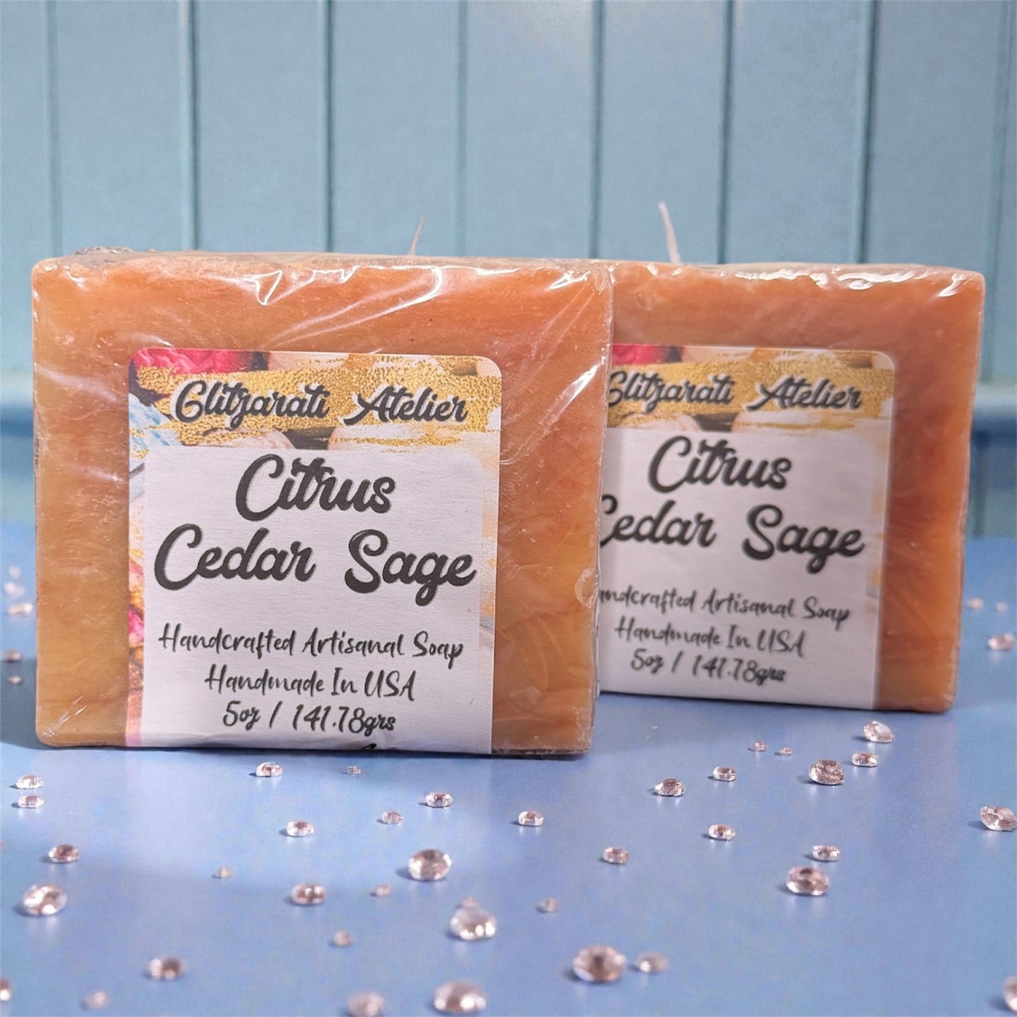 Two bars of Citrus Cedar Sage soap with a visible label on a blue background.