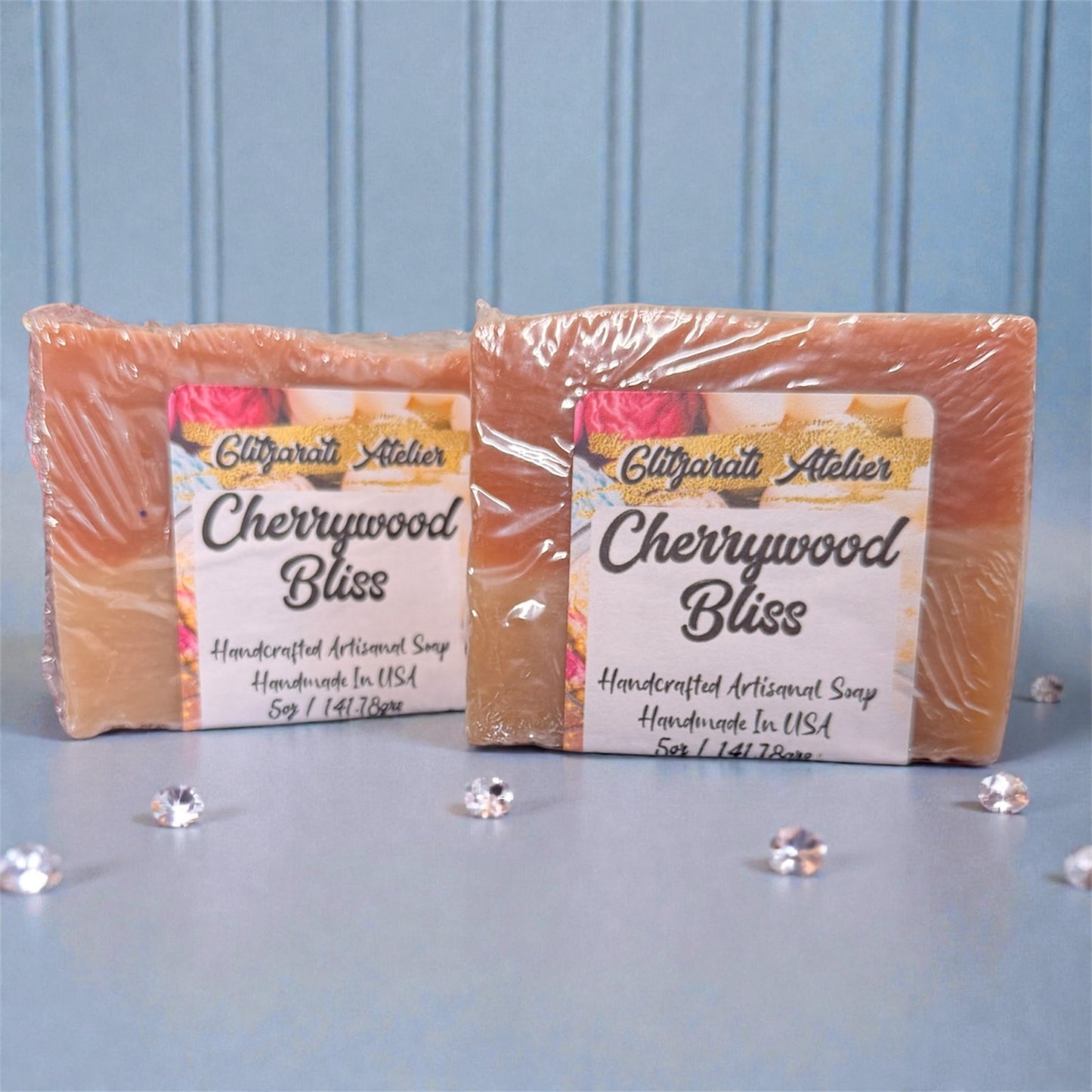 Two bars of Cherrywood Bliss soap from Glifgarati Atelier on a light blue background.