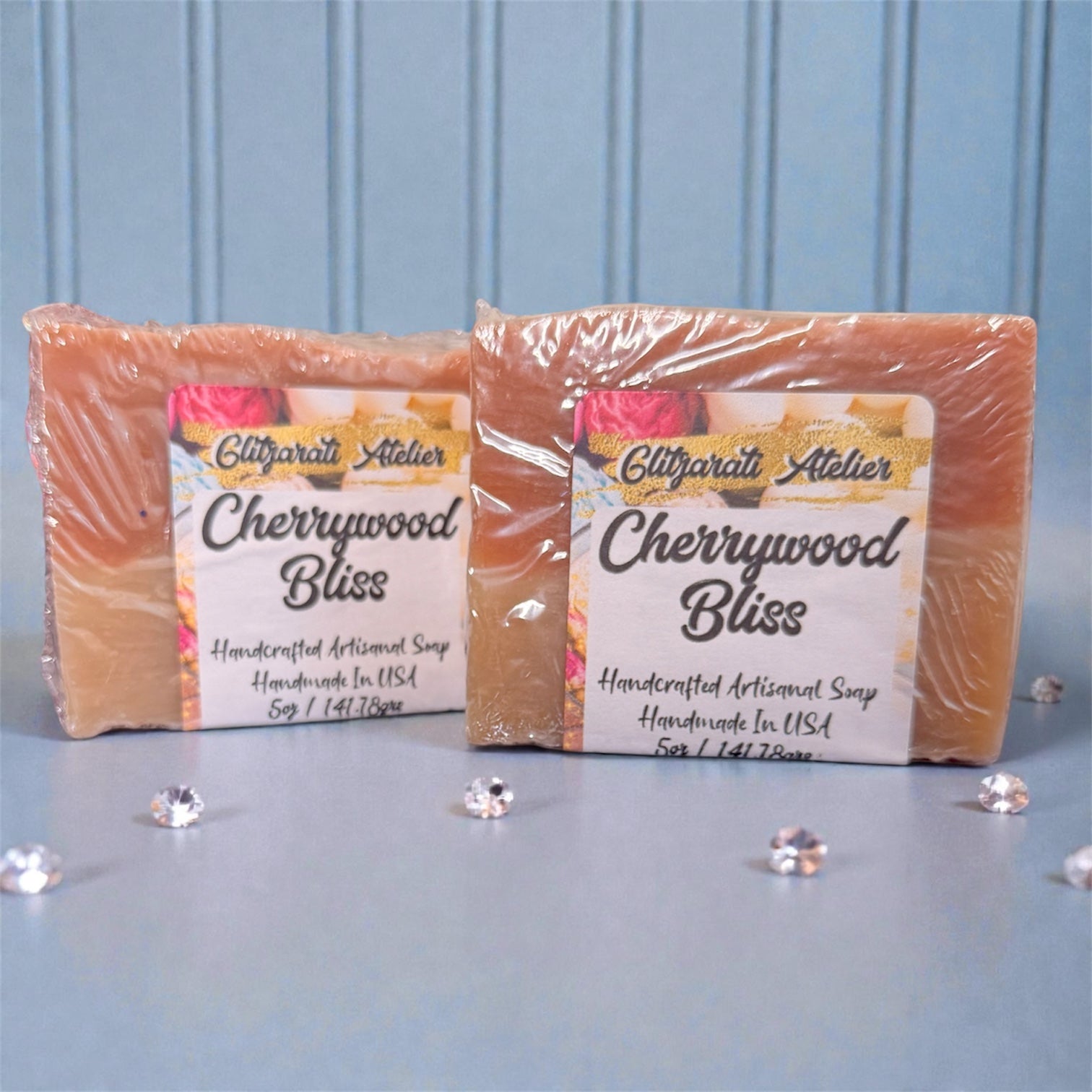 Two bars of Cherrywood Bliss soap from Glifgarati Atelier on a light blue background.