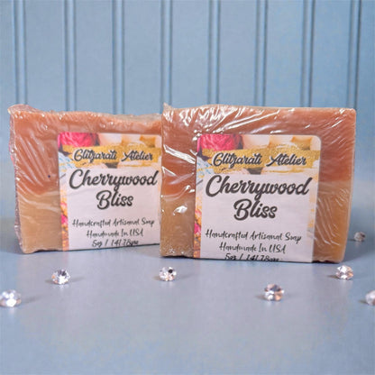 Two bars of Cherrywood Bliss soap from Glifgarati Atelier on a light blue background.