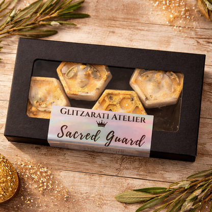 Box of 'Sacred Guard' products from Glitzarati Atelier on a wooden surface with decorative elements.