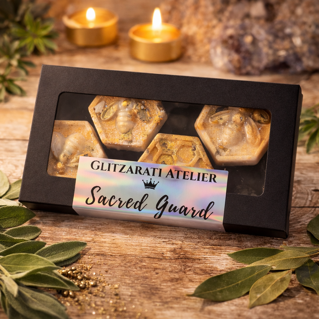 Box of 'Sacred Guard' products from Glitzarati Atelier on a wooden surface with candles and leaves.