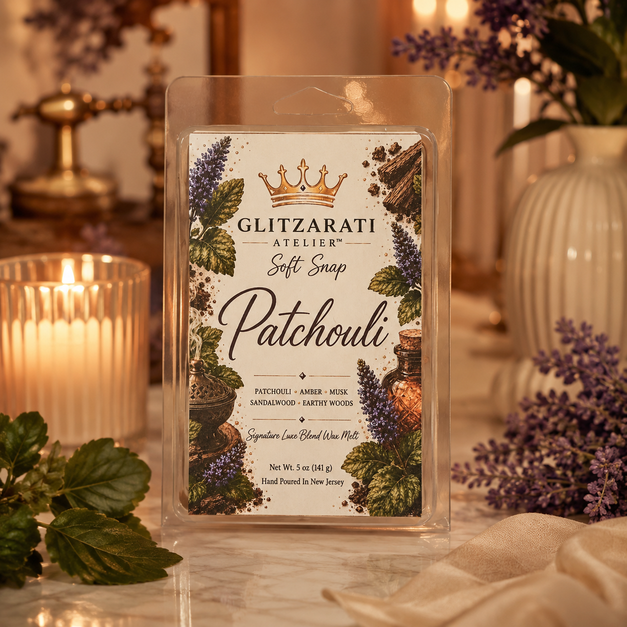 Glitzarati Atelier Patchouli wax melt packaging with decorative elements on a soft focus background.
