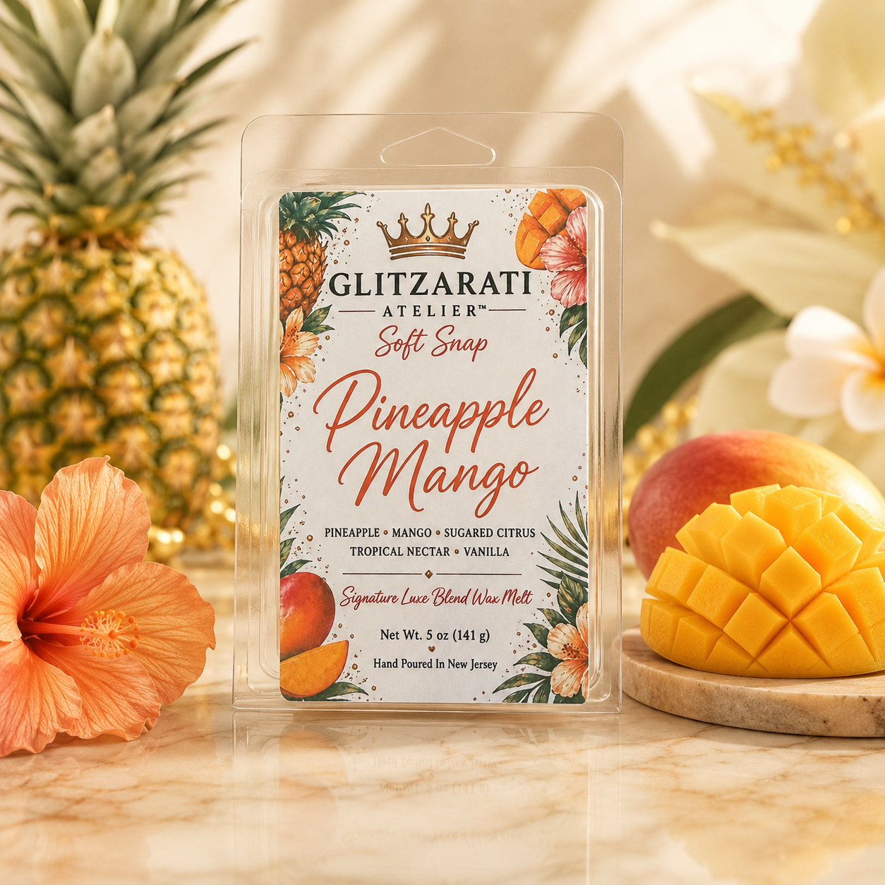 Glitzerati Atelier Pineapple Mango wax melt packaging with pineapple and mango on a wooden surface.