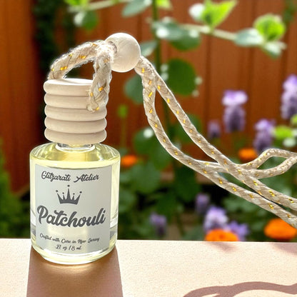 Patchouli essential oil diffuser bottle with rope on a blurred natural background