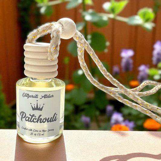 Patchouli essential oil diffuser bottle with rope on a blurred natural background
