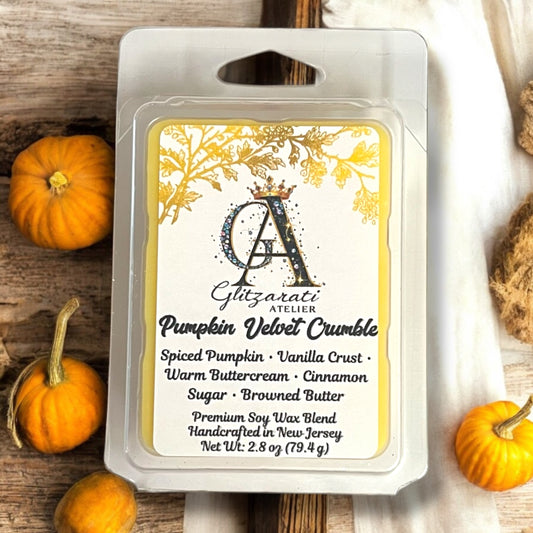 Gltizarati Atelier Pumpkin Velvet Crumble wax melt packaging with pumpkins on a wooden surface