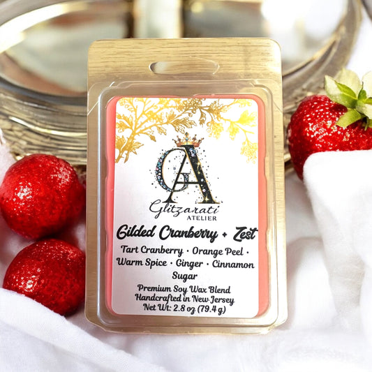 Gilded Cranberry & Zest wax melt packaging with strawberries in the background