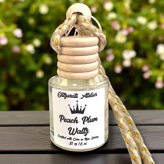 Perfume bottle with wooden cap and rope handle on a wooden surface with blurred greenery in the background