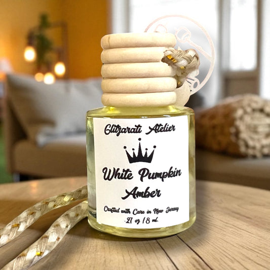 Bottle of 'White Pumpkin Amber' fragrance with wooden cap on a wooden surface.