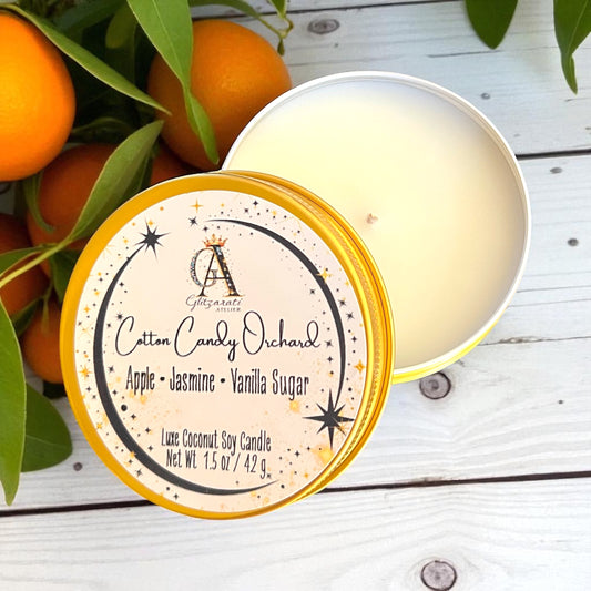 Candle with label and oranges on a wooden surface