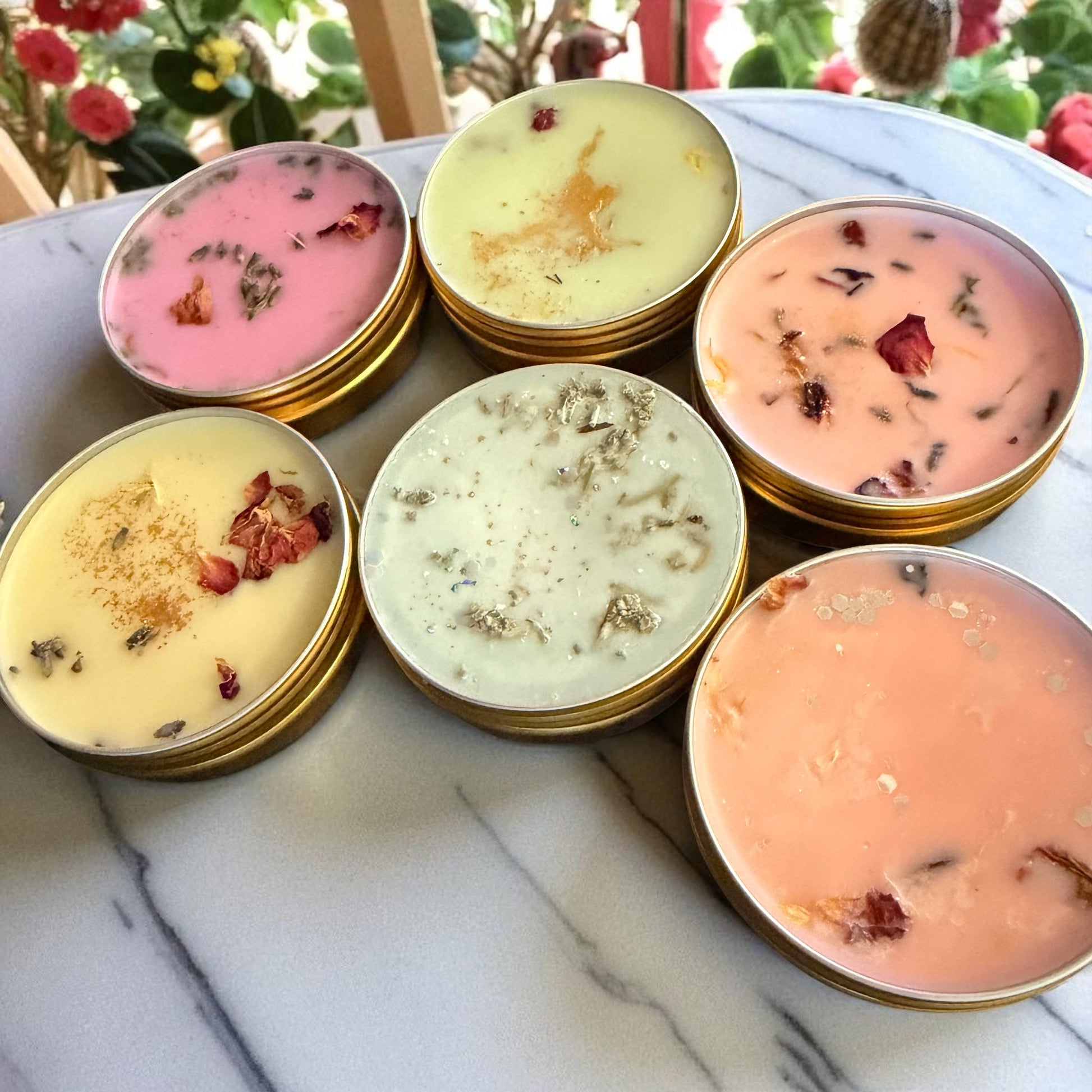 Assorted small containers with colorful contents on a marble surface with a floral background