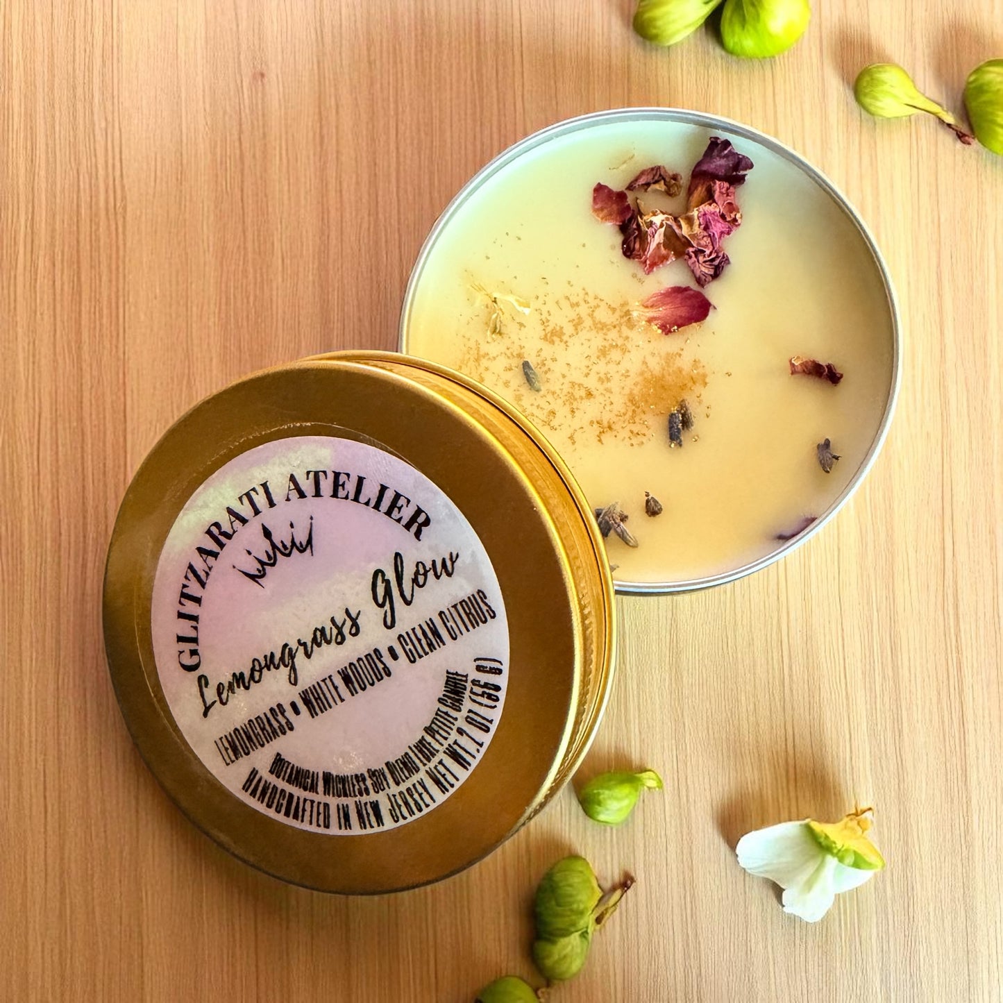 Candle in a tin with decorative elements on a wooden surface