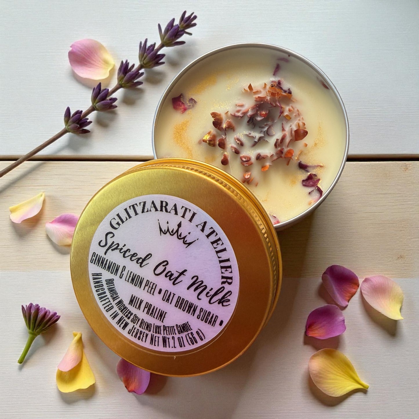 Spiced Oat Milk product with lid on a wooden surface surrounded by flowers