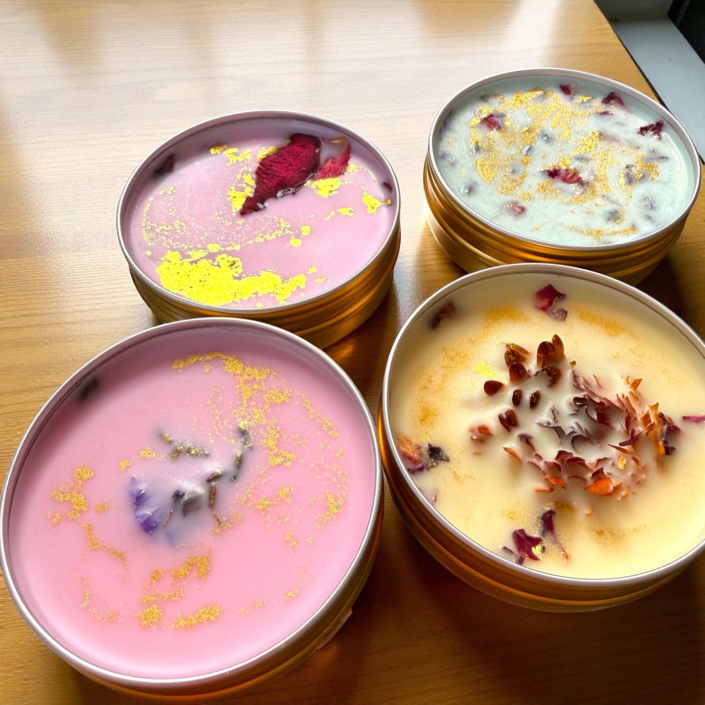 Four small containers of dessert with decorative elements on a wooden surface