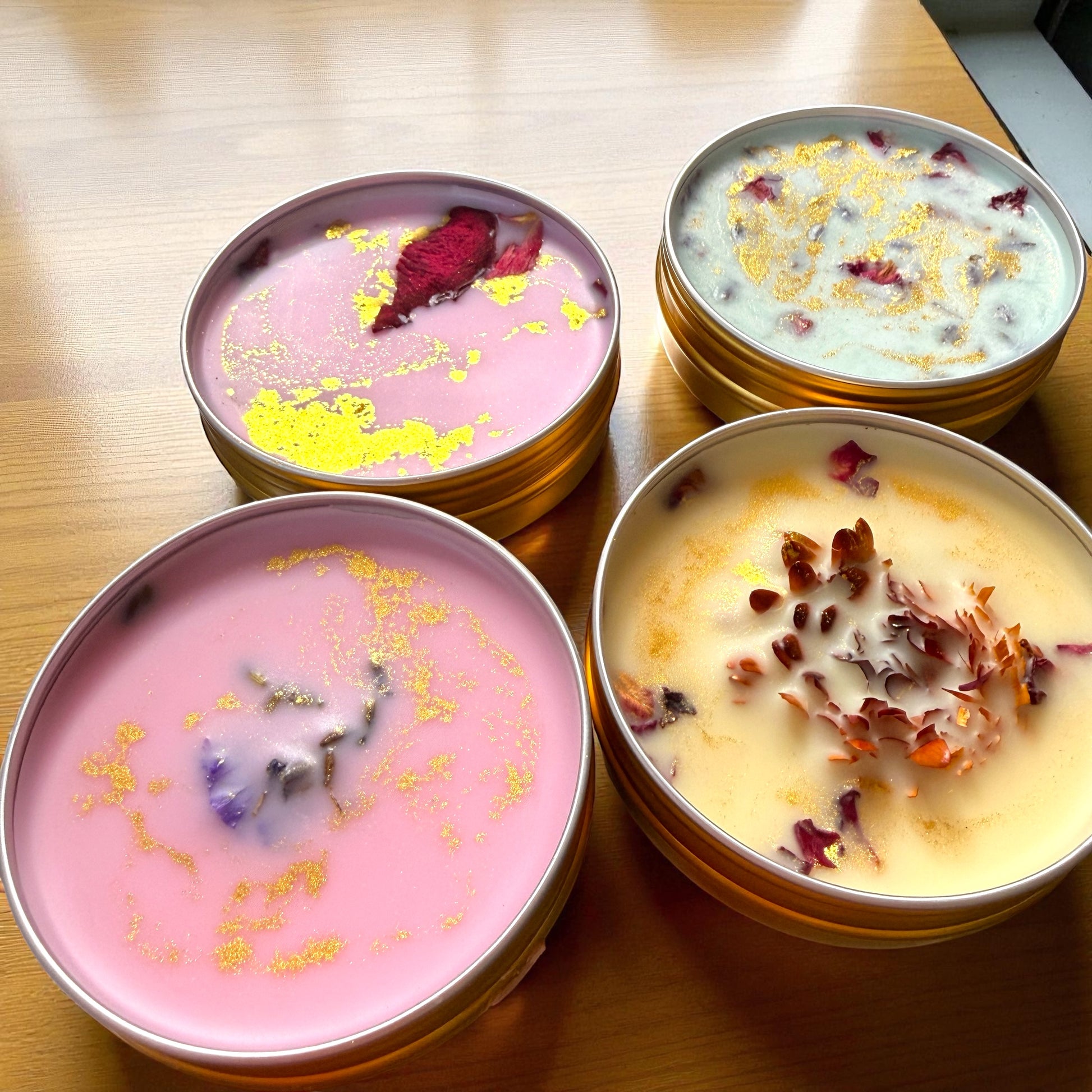 Four small containers of dessert with decorative elements on a wooden surface