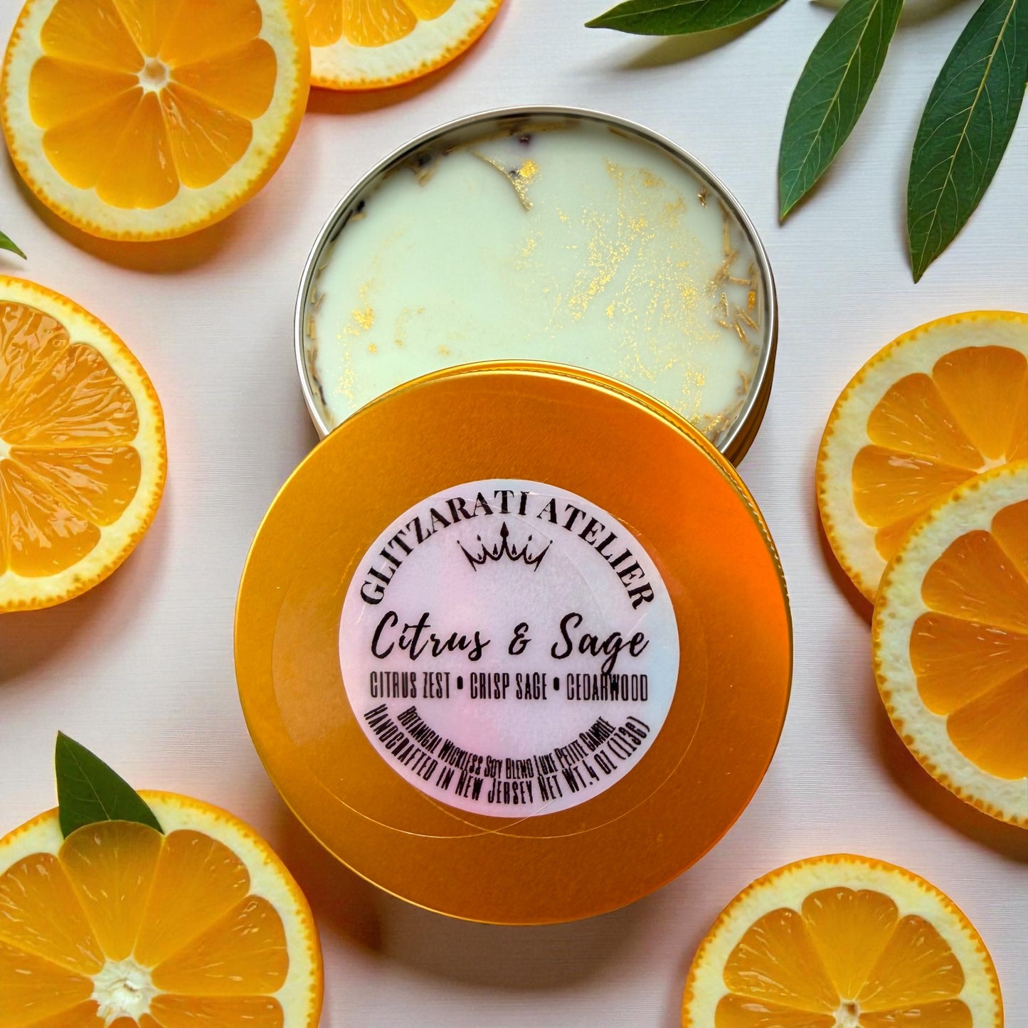 Orange-colored container with a label surrounded by sliced oranges and leaves on a light background