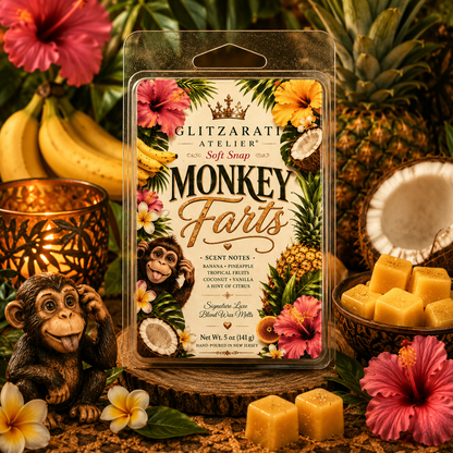 Packaged product with 'Monkey Farts' scent from Glitzarati Atelier, surrounded by tropical elements like flowers and fruits.