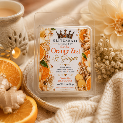 Glitzerati Atelier Orange Zest & Ginger wax melt packaging with oranges and flowers in the background